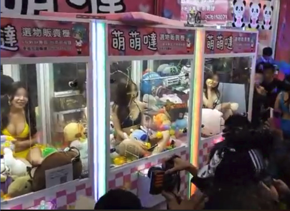 台湾のゲームセンターのufoキャッチャーの中にビキニ姿の本物の女性が